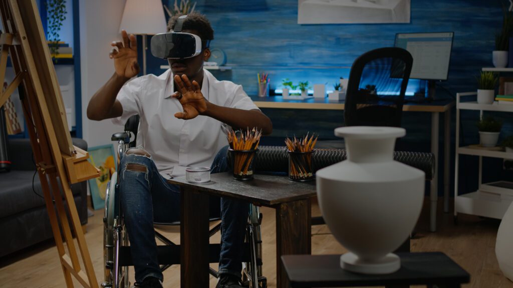 Disabled african american man using vr glasses for inspiration and virtual drawing in workshop studio. Black young artist in wheelchair with technology for modern masterpiece process